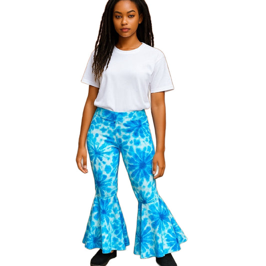 Woman wearing a white t-shirt and blue tie-dye flared pants on a white background