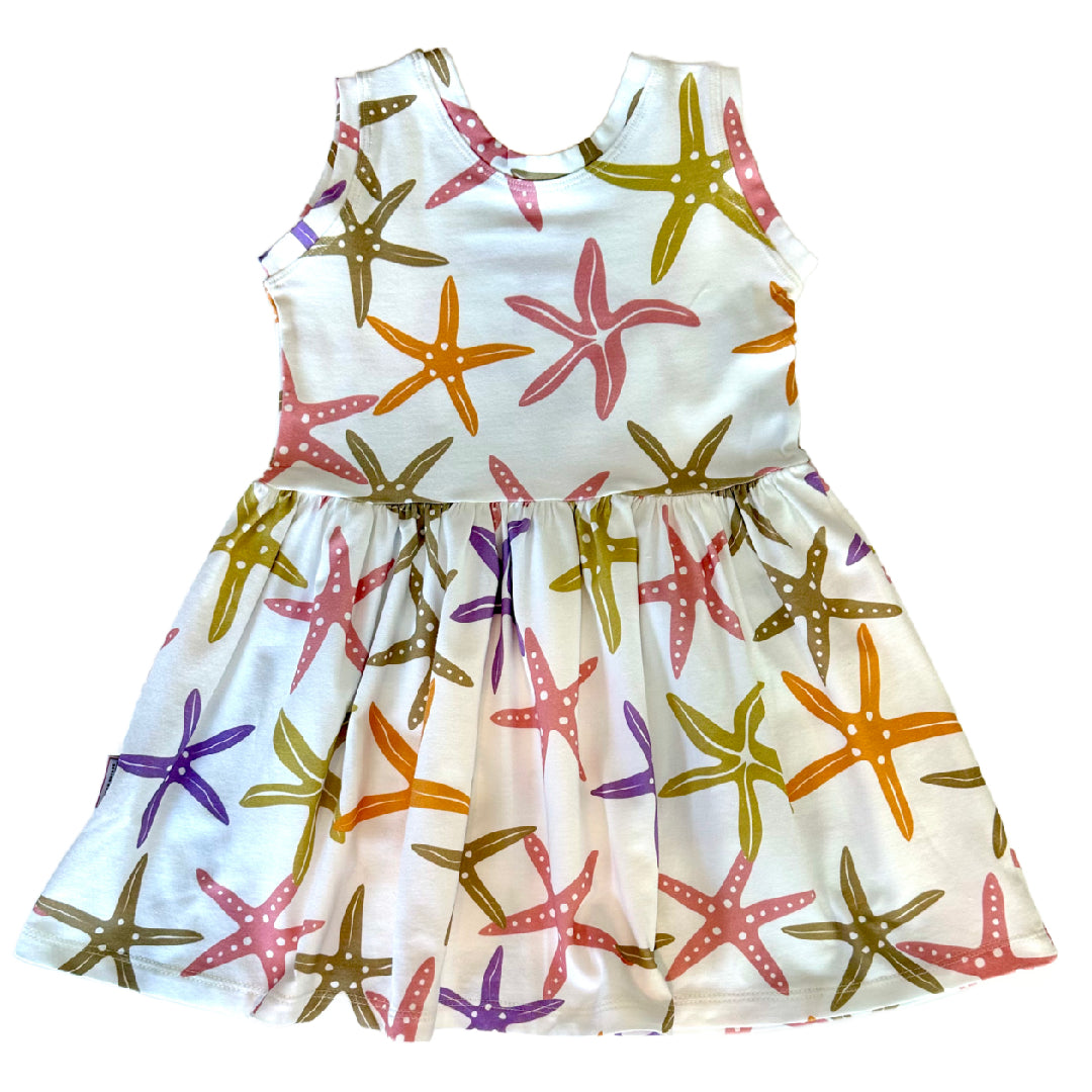 White dress with colorful starfish pattern on a plain background