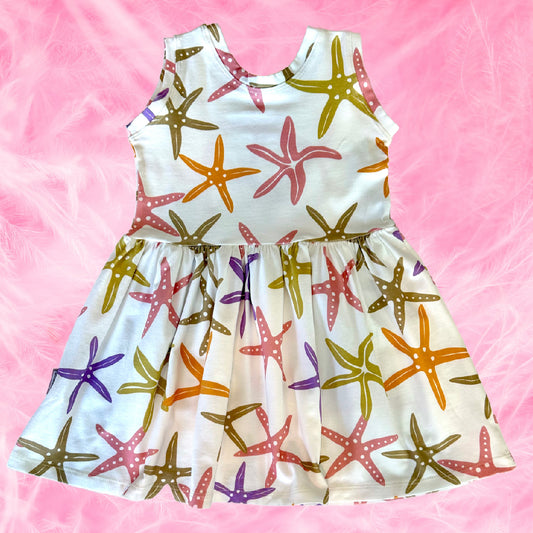 Dress with colorful starfish pattern on a pink background
