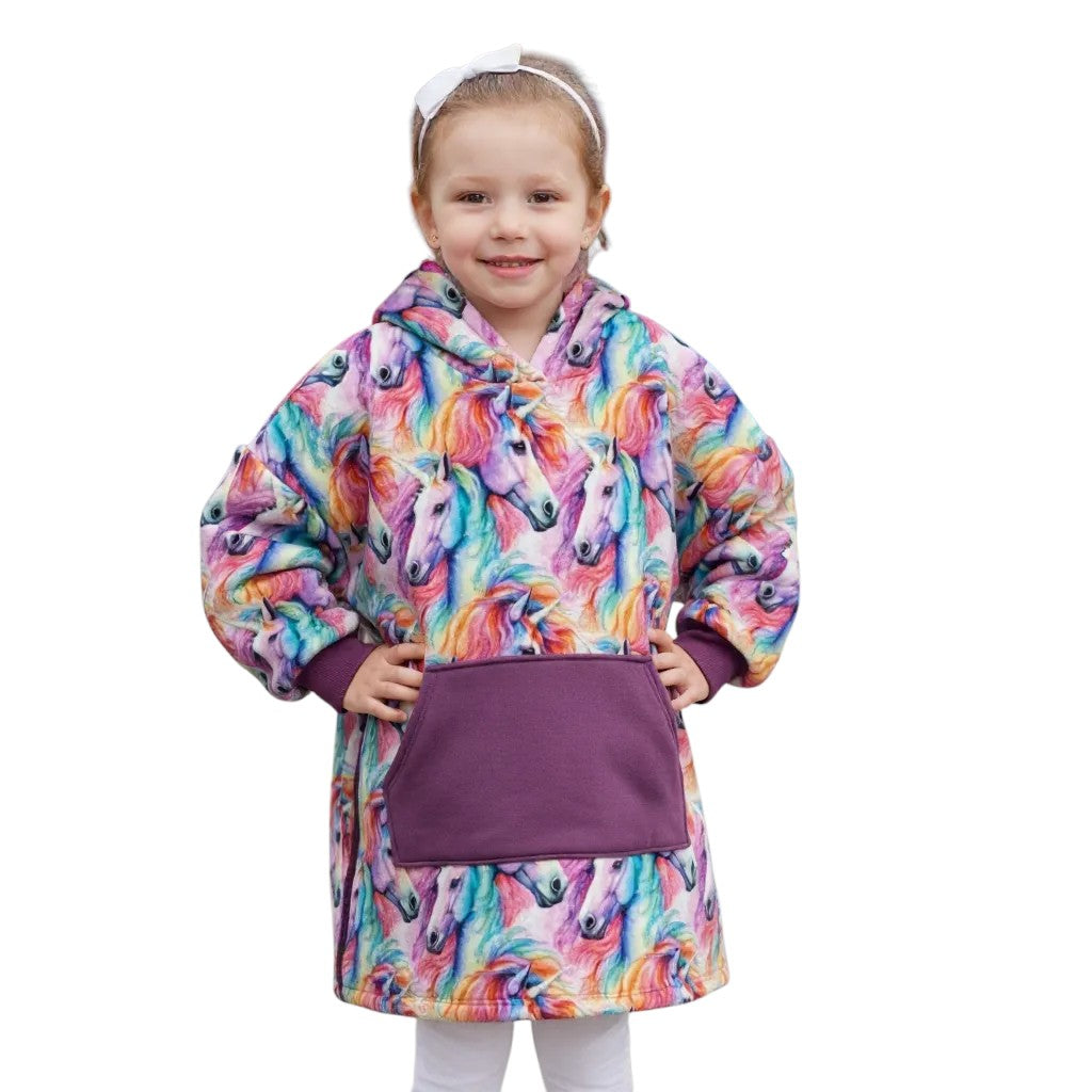 Child wearing a colorful unicorn hoodie with a purple pocket on a white background