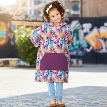 Child wearing a colorful unicorn hoodie with a purple pouch in an urban setting.